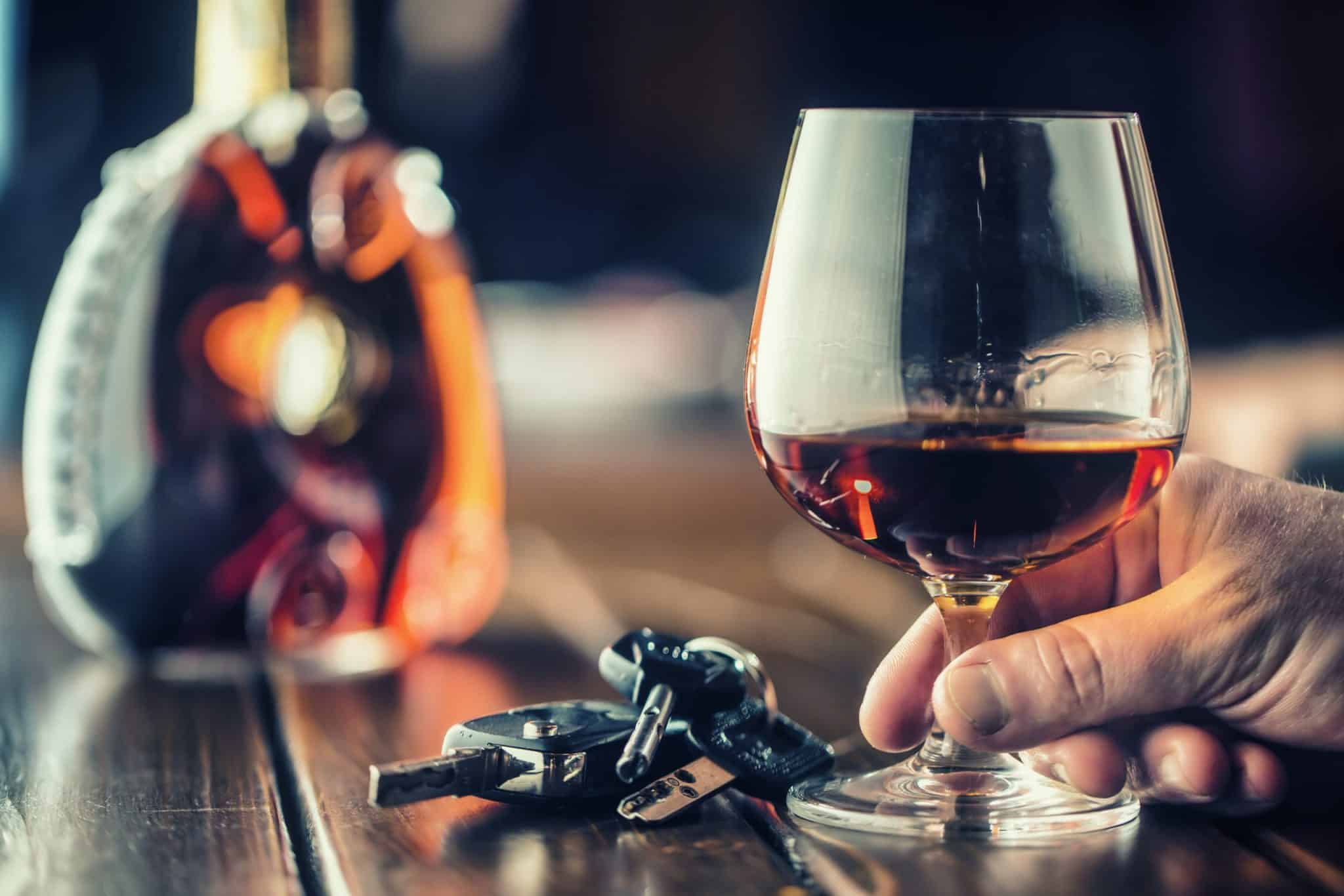 picture of brandy snifter with blurred brandy bottle and car keys in background
