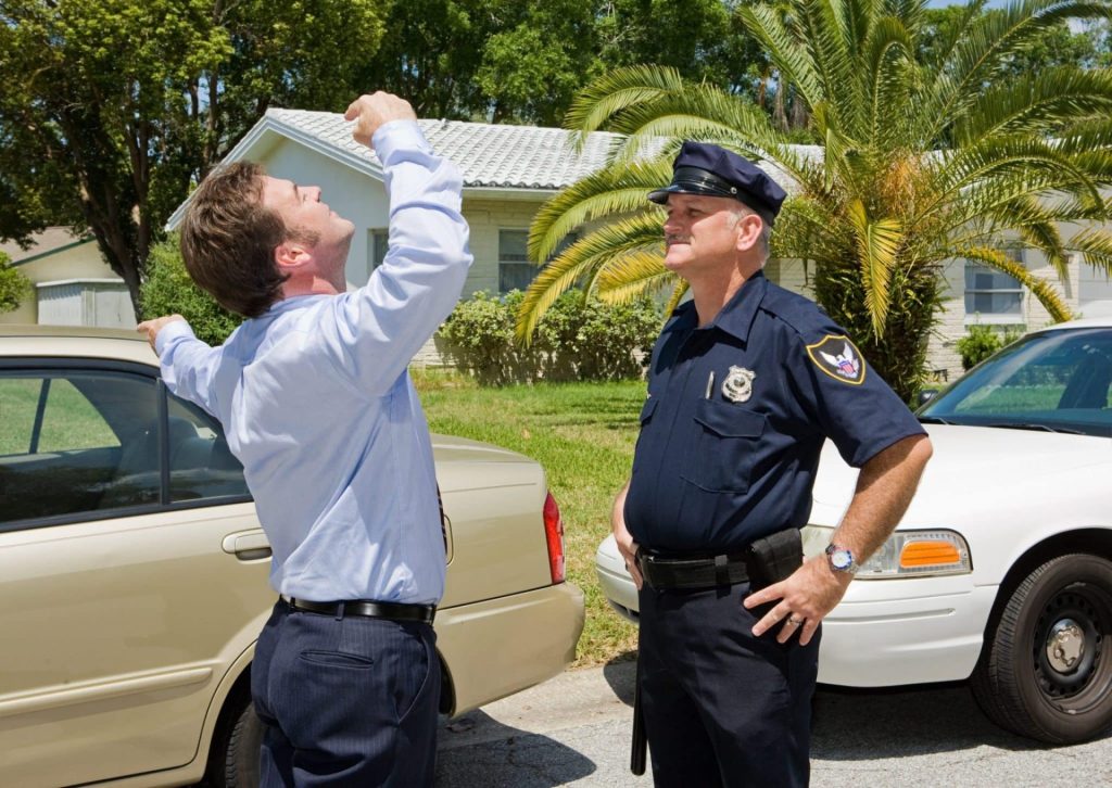 man taking field sobriety tests next to a police officer