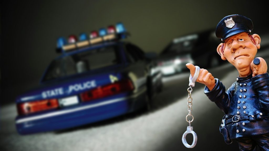 caricature of officer dangling handcuffs behing a police cruiser