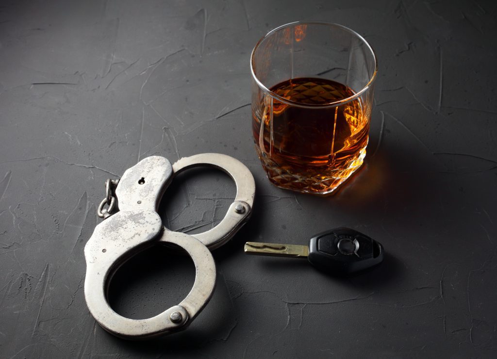 cocktail hadcuffs and car keys on a table