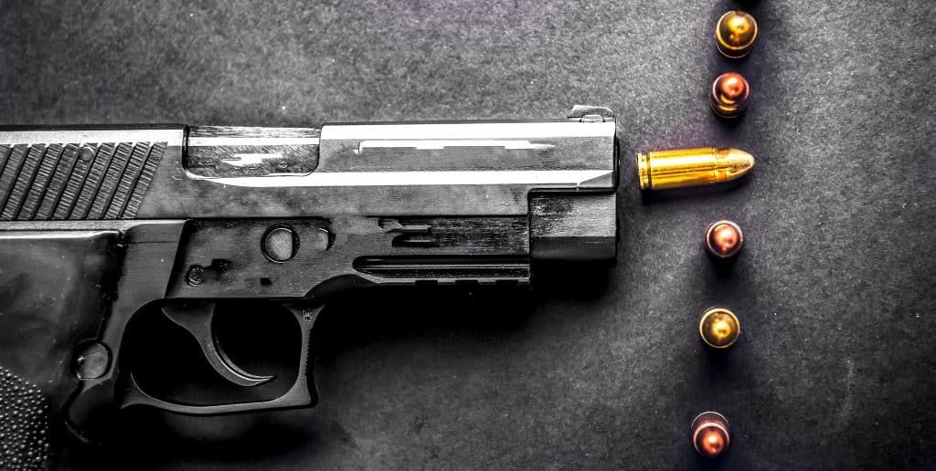 semi-automatic pistol with bullets laying on table