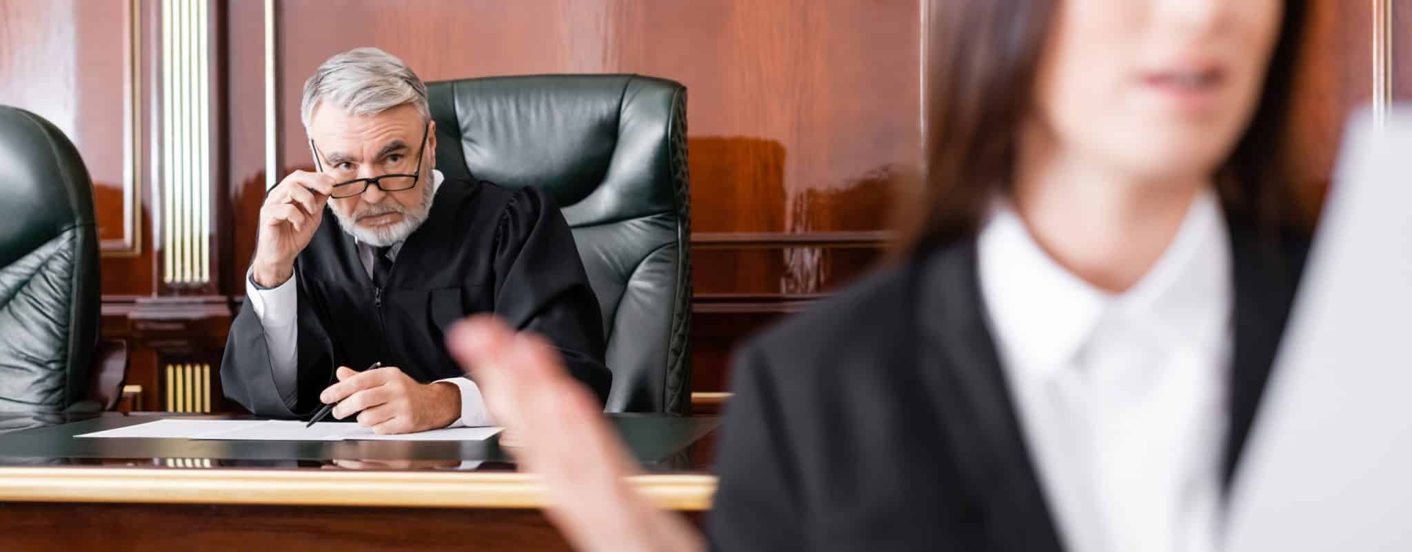 a judge sitting on bench looking at female lawyer