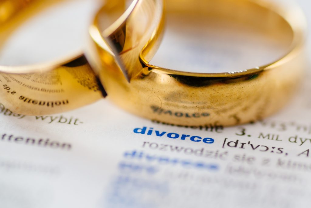 two wedding rings on top of paper saying divorce