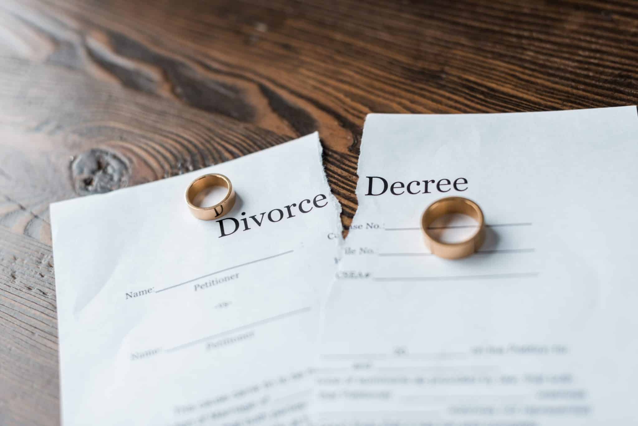 two wedding rings on torn divorce decree